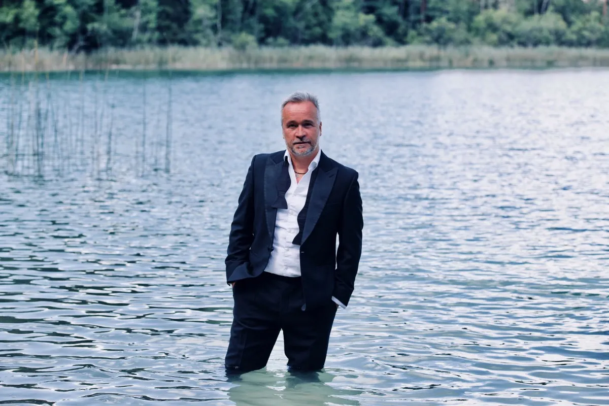 Thomas Darchinger im Anzug, knietief in einem See stehend